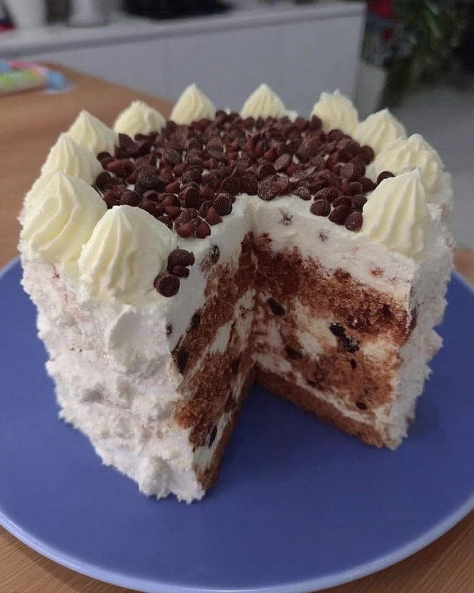 Whole chocolate layer cake topped with fresh raspberries and blueberries