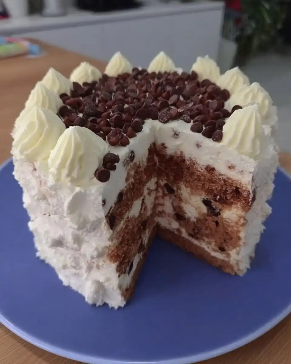 Whole chocolate layer cake topped with fresh raspberries and blueberries