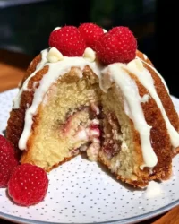 Slice of chocolate raspberry cake showing layers of filling and chocolate frosting