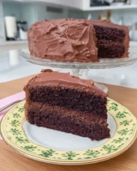 Slice of moist Devil's Food cake on a white plate with a fork