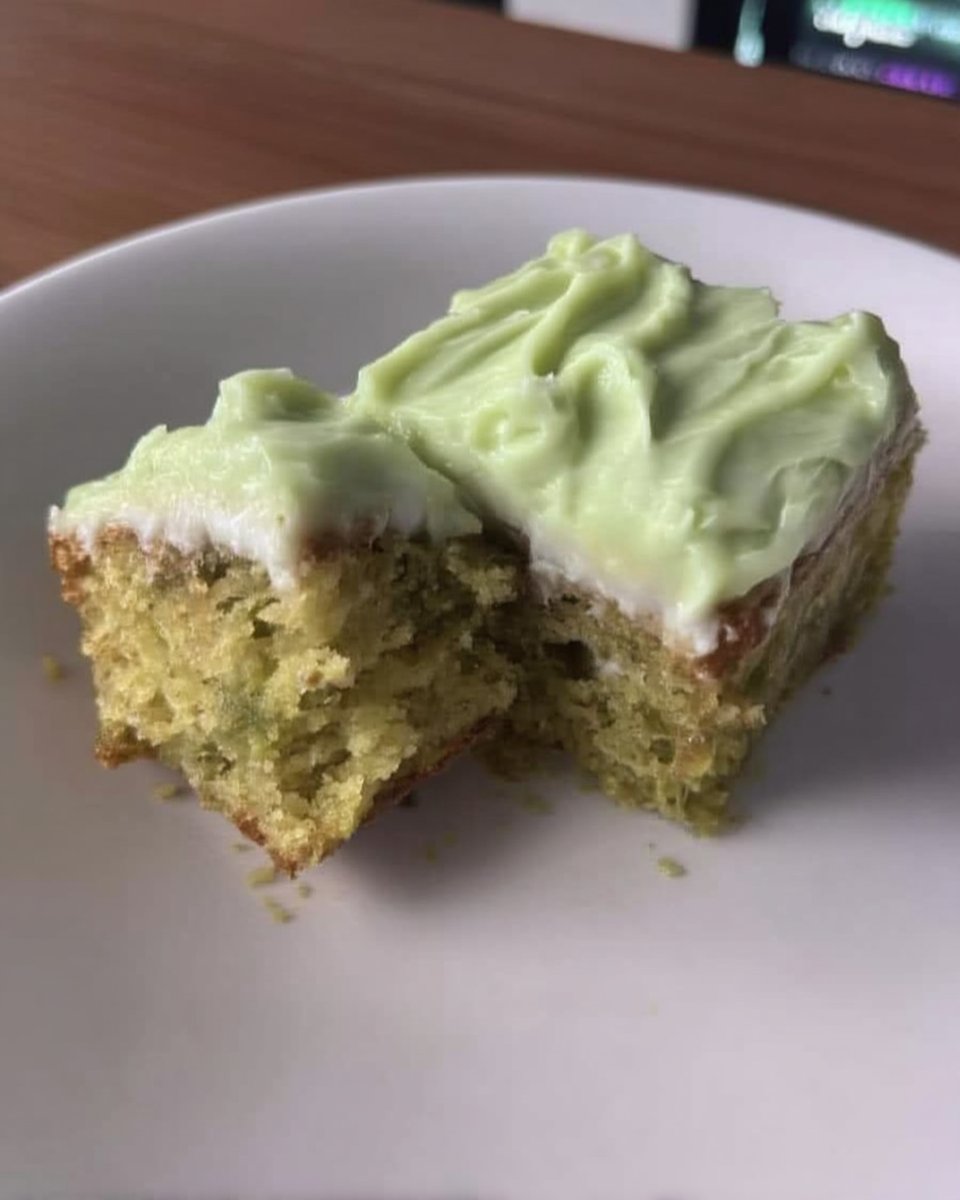 Green cake batter being mixed in a bowl with a spatula