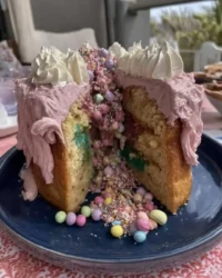 Sliced pinata cake with colorful candy spilling out from the center