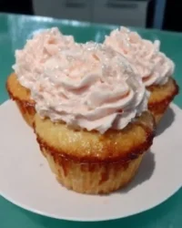 Slice of pink champagne cake with fluffy buttercream frosting on a plate