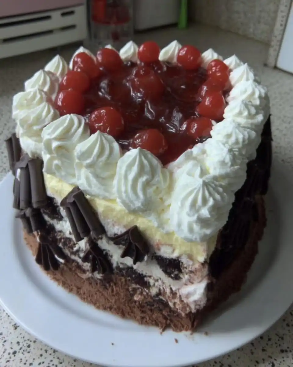 Whole black forest cake served with a cup of coffee