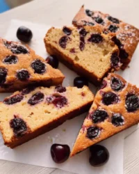 Slice of fresh cherry cake on a white plate