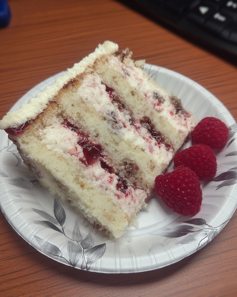 Piece of raspberry cake served with a cup of coffee