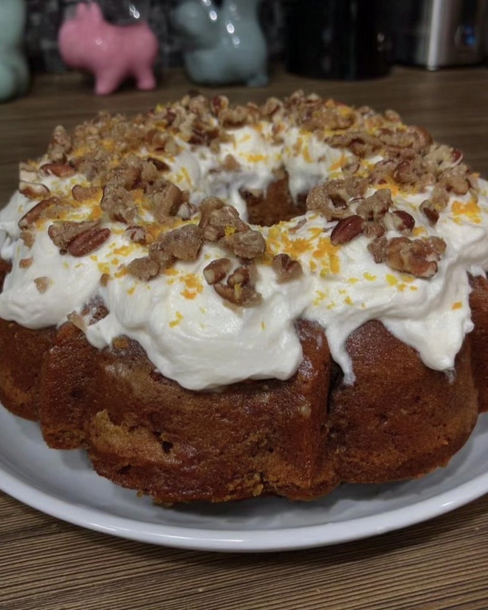 Slice of carrot cake on a white plate showing moist crumb and raisins