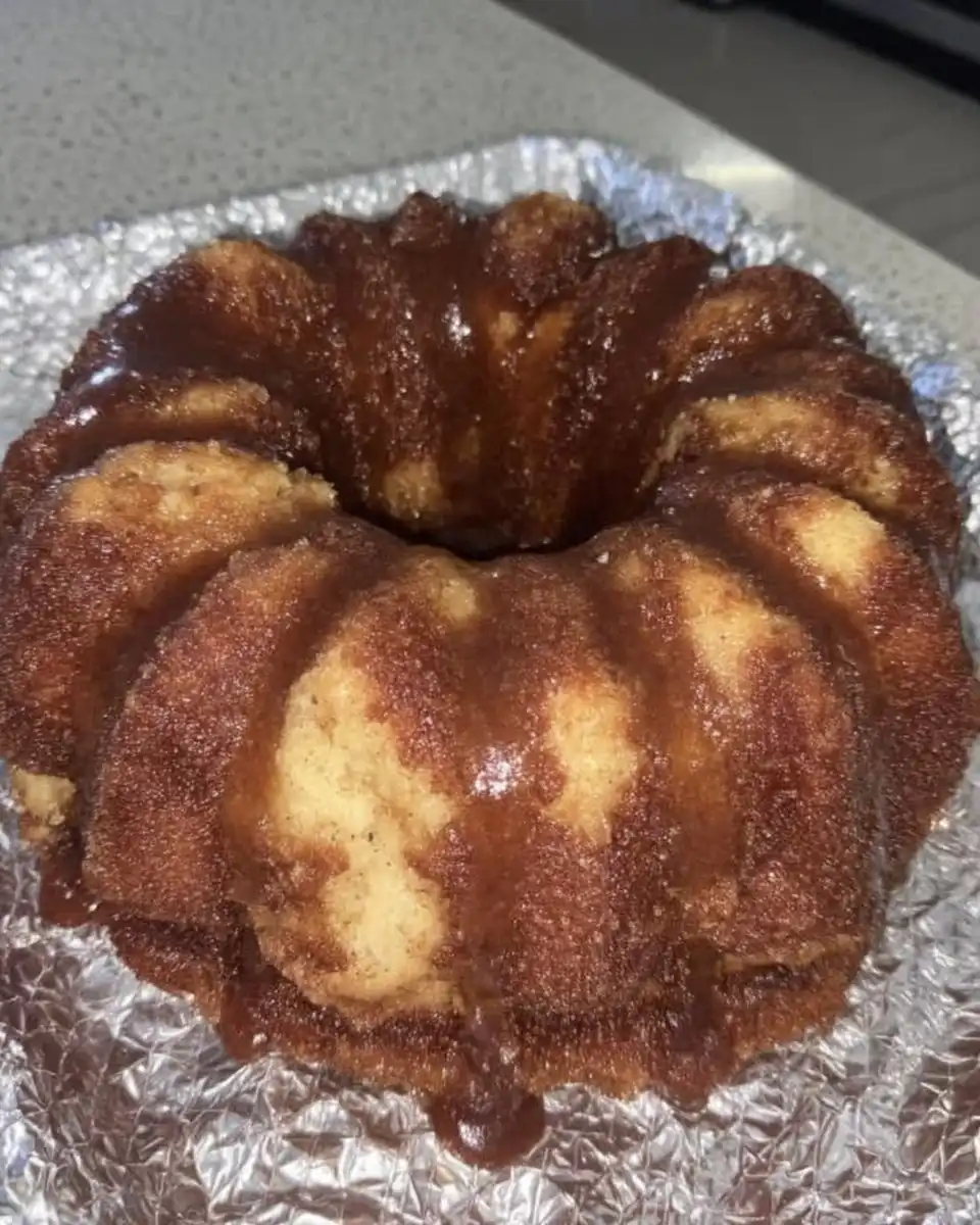 Slice of sour cream bundt cake served with fresh raspberries and whipped cream