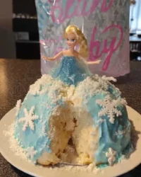 Slice of green princess cake showing layers of sponge jam and cream