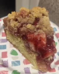 Slice of moist strawberry rhubarb cake on a white plate