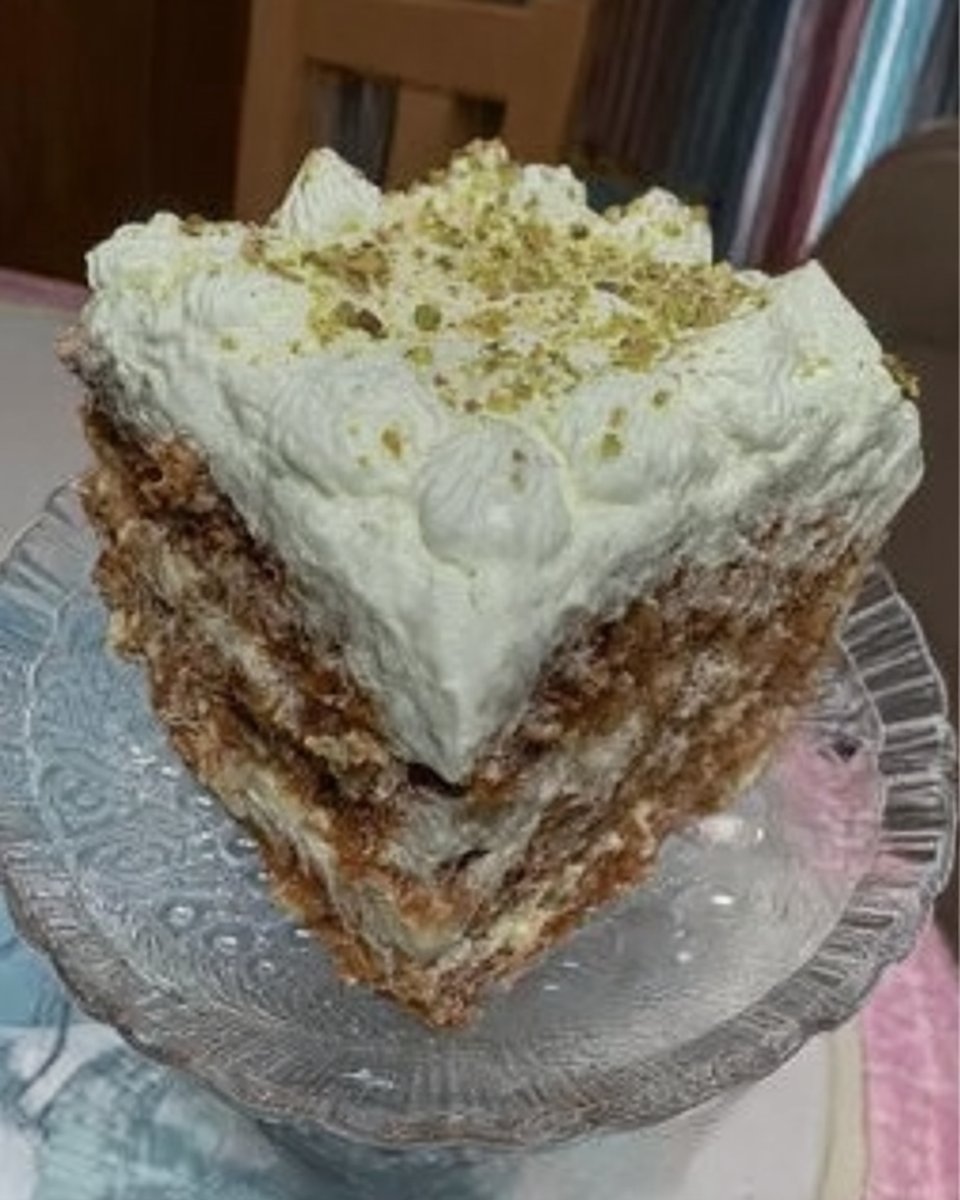 Slice of green watergate cake with pistachio frosting on a white plate