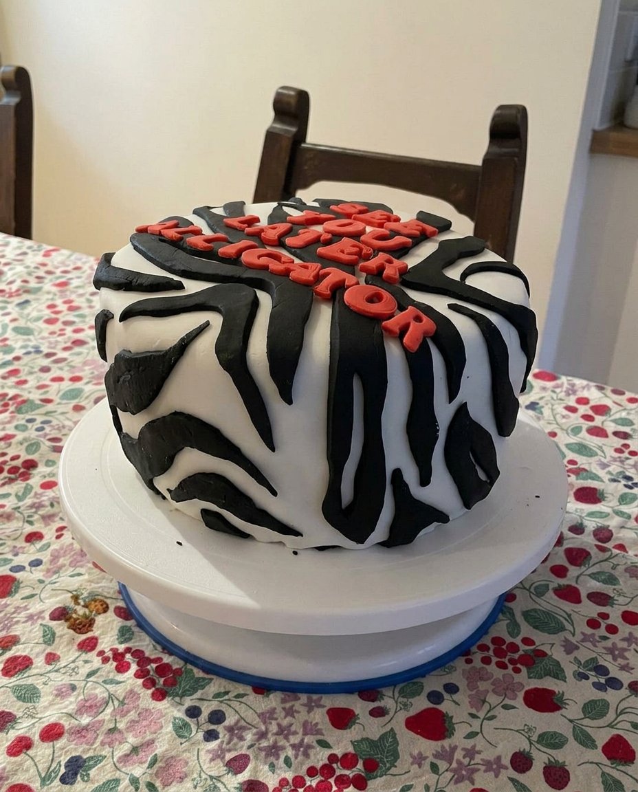 A beautiful aesthetic cake with chocolate frosting on a simple cake stand