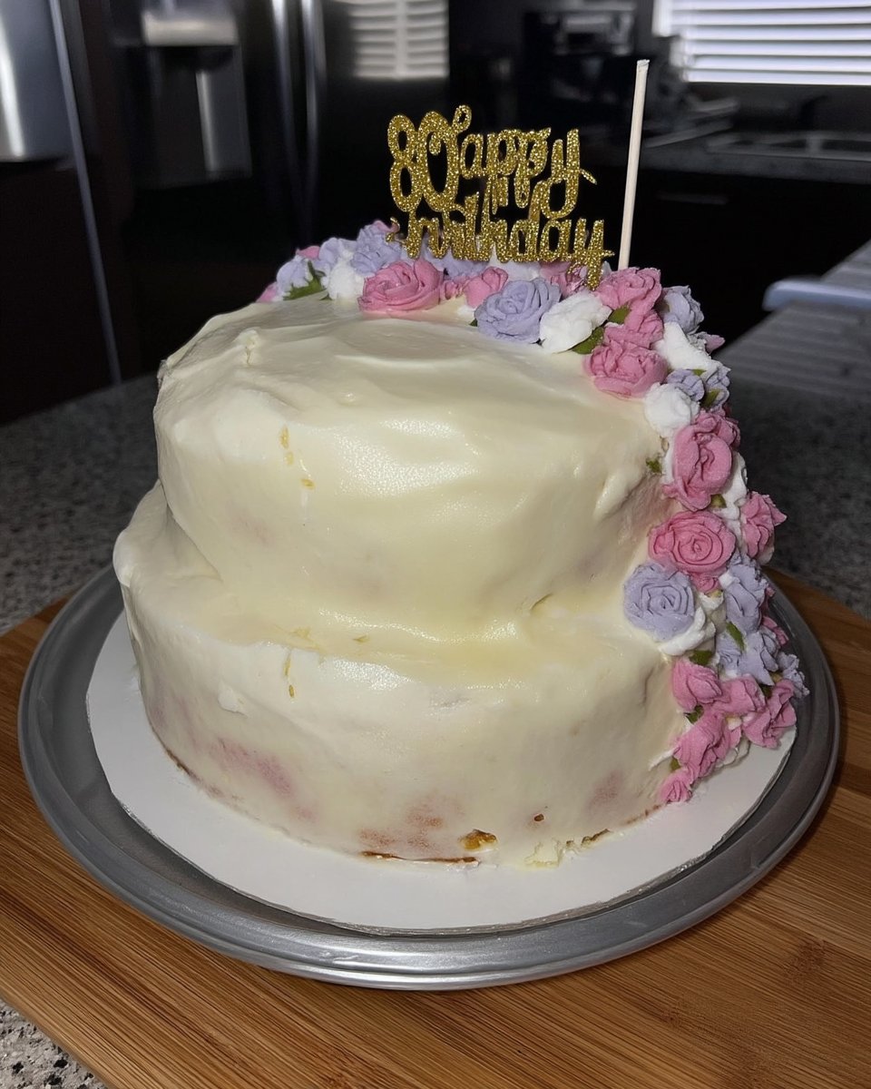 A beautiful floral cake decorated with colorful buttercream flowers on a white stand.