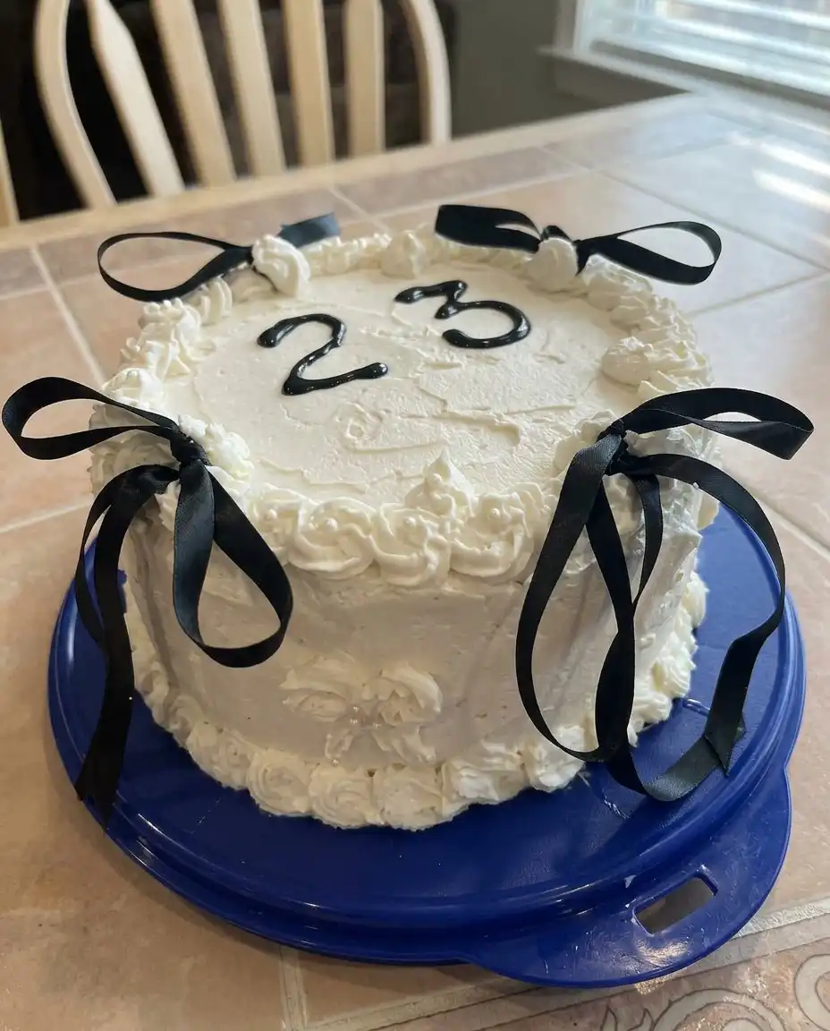 Ingredients for birthday cake including flour, eggs, milk, and extracts on a marble countertop