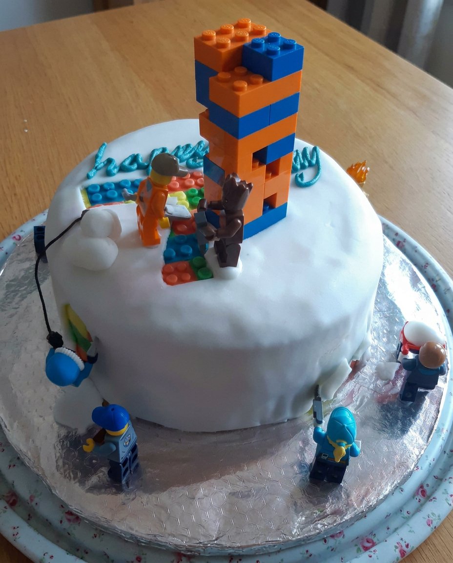 A rectangular boys cake decorated like a soccer pitch with green grass frosting and figurines