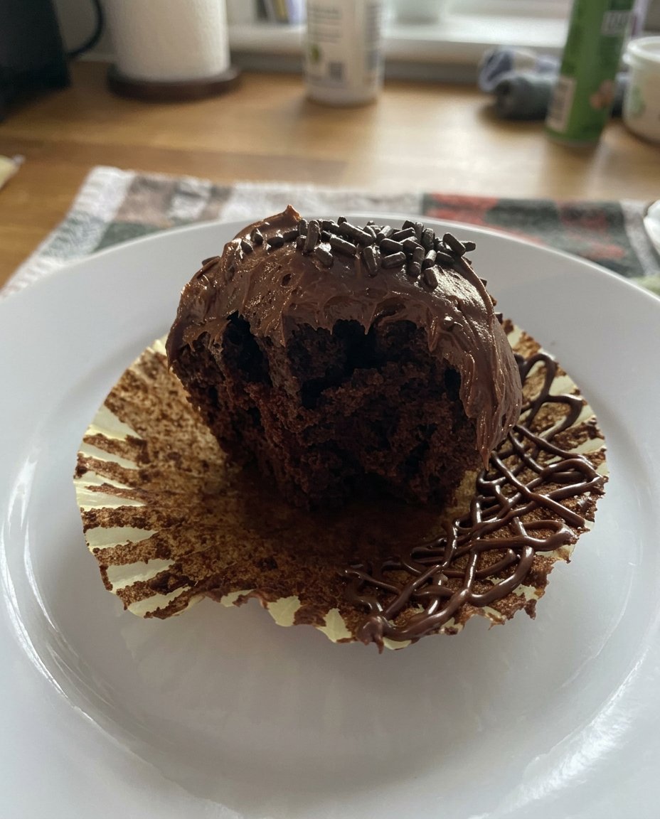 A close up of someone smoothing chocolate frosting on a cake