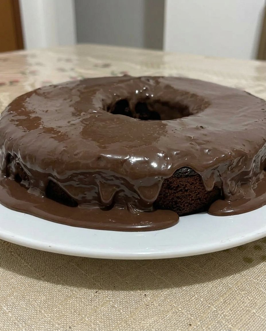 A slice of chocolate cake with thick buttercream frosting on a plate