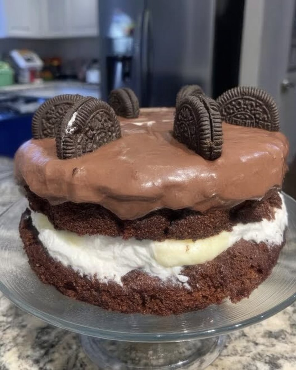 Bowl of chopped Oreo cookies next to flour, butter, and sour cream on a kitchen counter