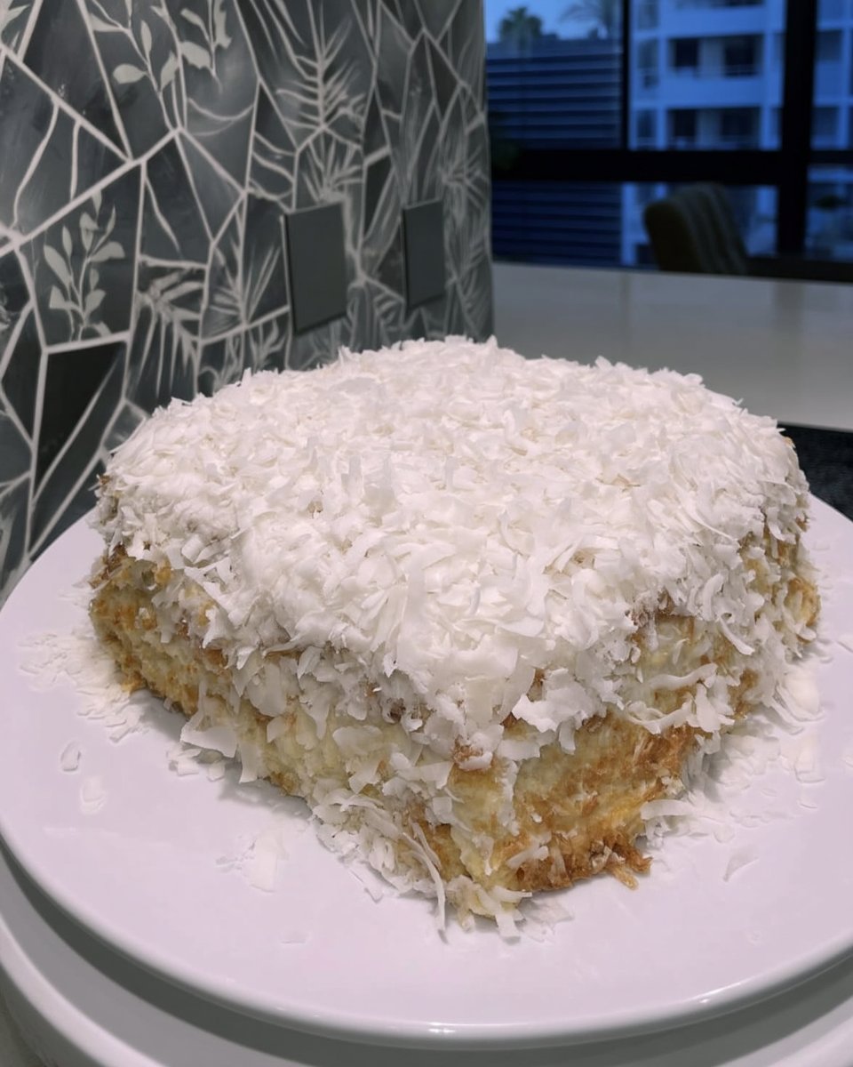 Canned coconut milk and coconut extract on a kitchen counter
