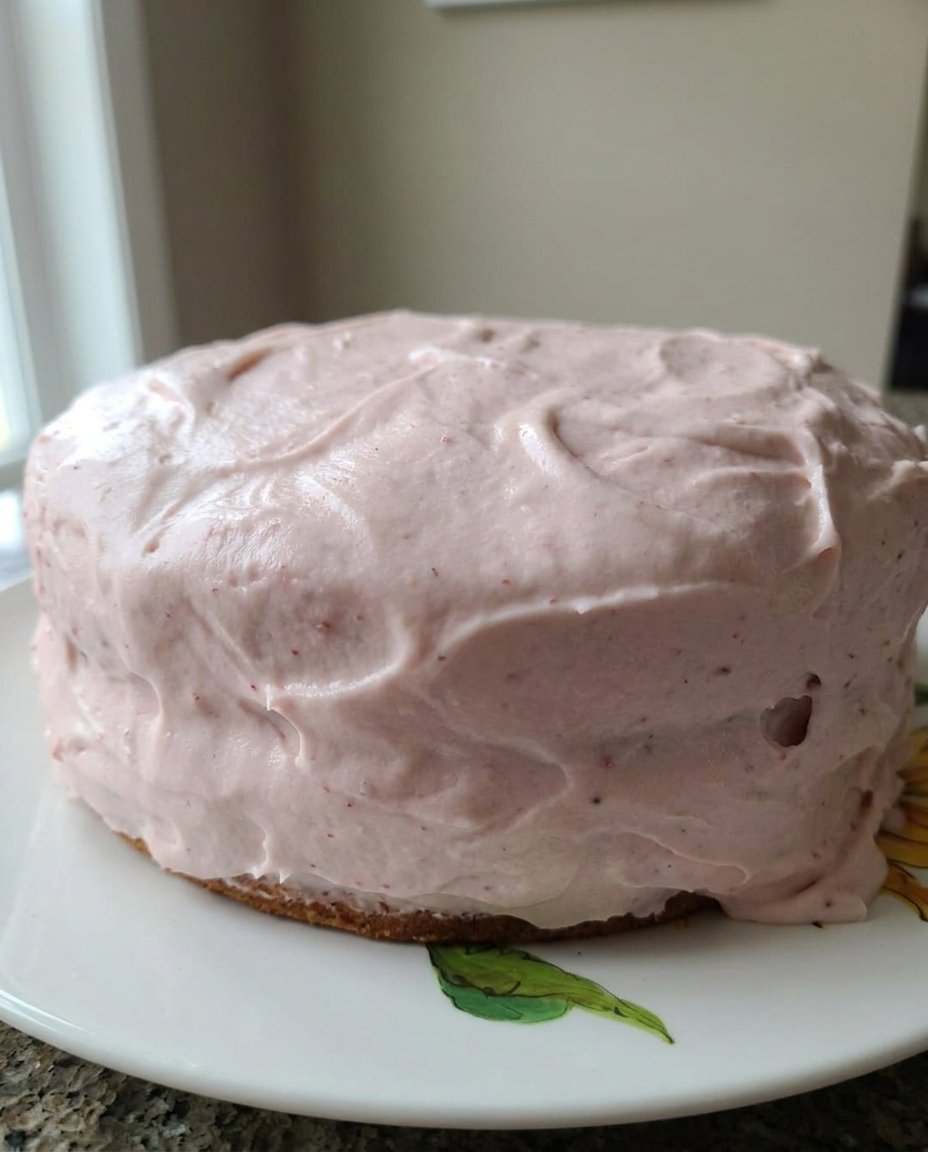 A slice of strawberry cake on a plate with a fork