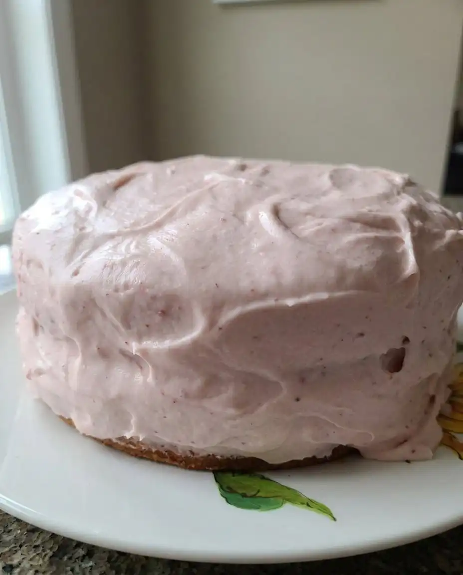 A slice of strawberry cake on a plate with a fork