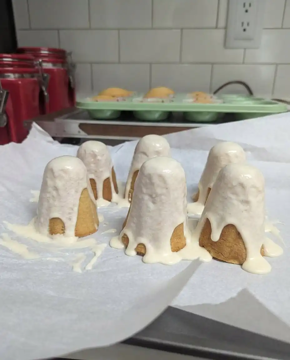 Ghost cake served on a dark plate with Halloween decorations nearby