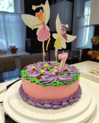 A beautiful girl cake with pink ombre rosettes and a doll topper.