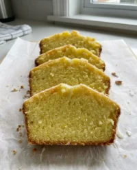 A golden brown lemon pound cake cooling on a wire rack