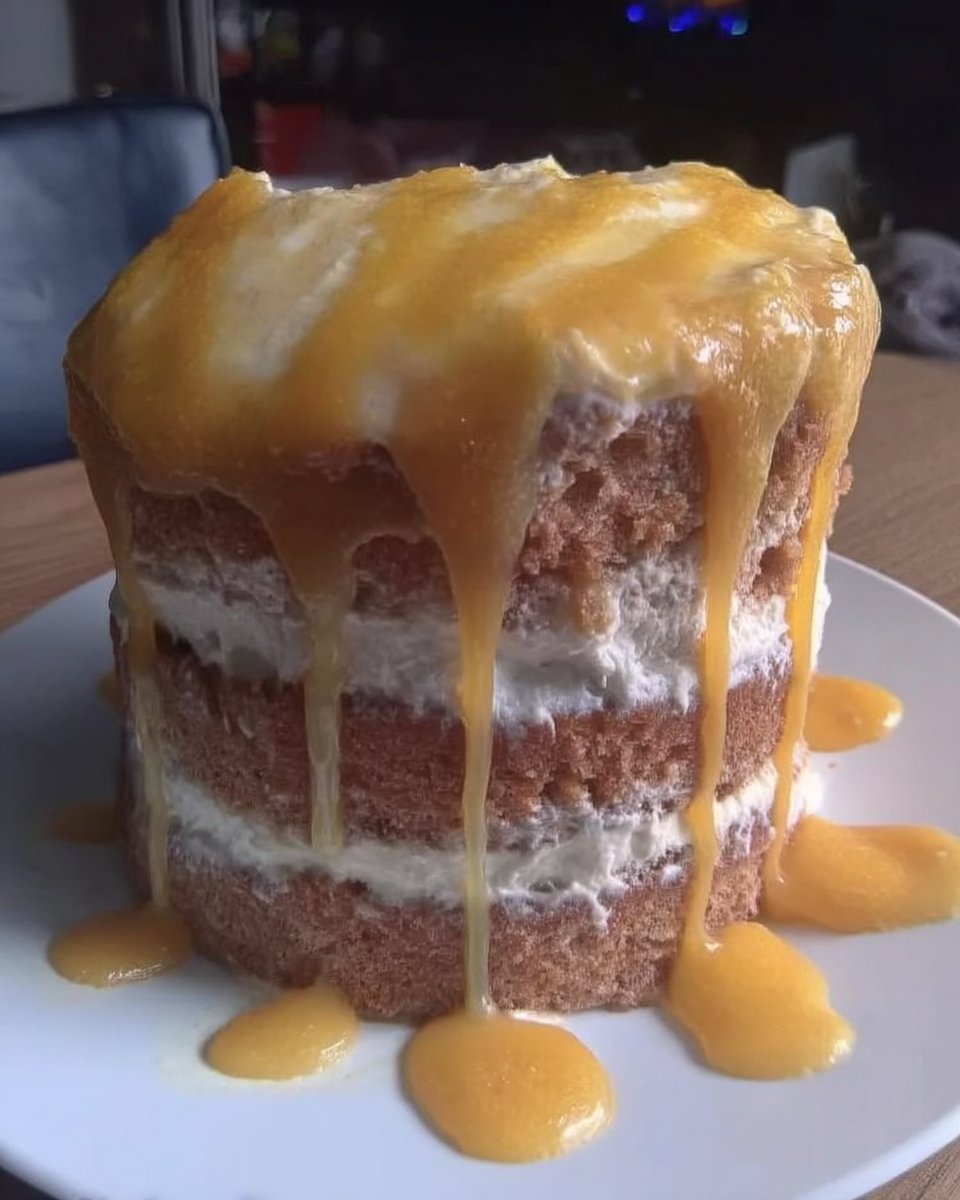 A slice of three-layered lemon rainbow cake with yellow orange and green layers