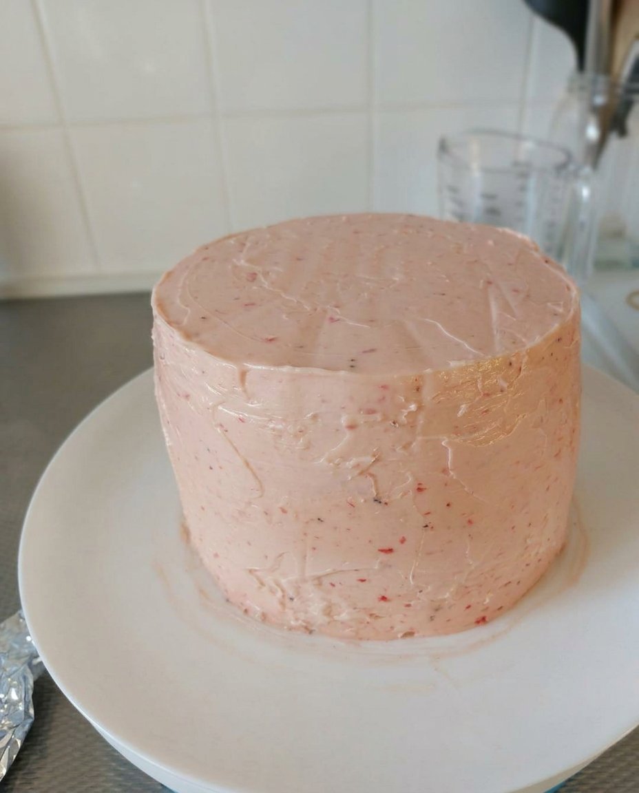 Pink strawberry cake batter being mixed in a bowl