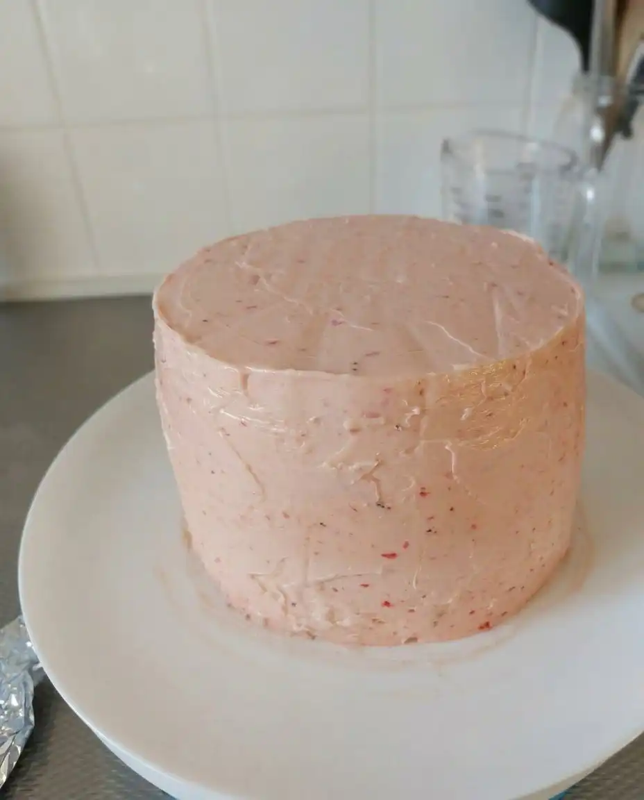 Pink strawberry cake batter being mixed in a bowl