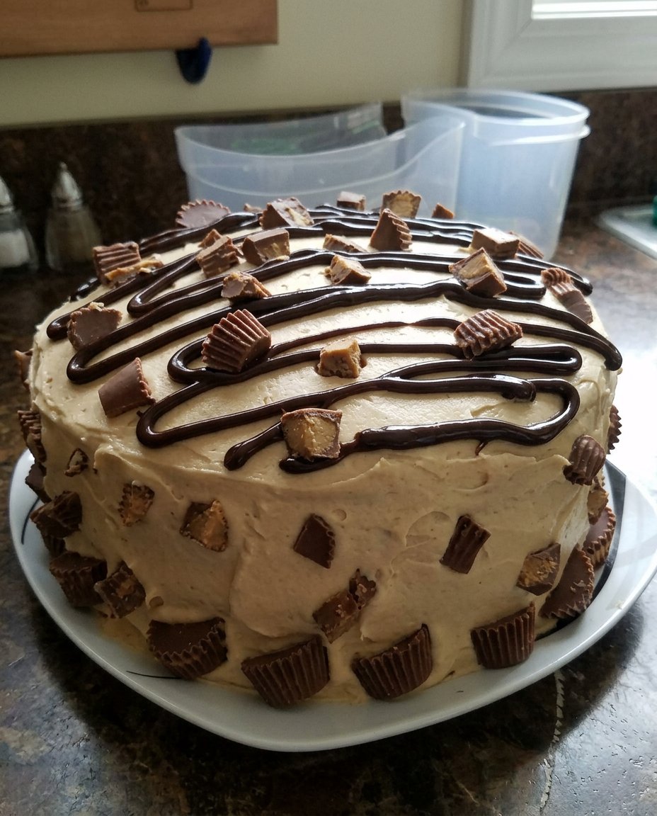 A hand mixer blending cake batter in a large glass bowl.
