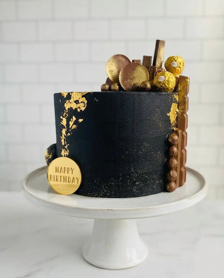 A hand painting gold luster dust onto white chocolate drips on a cake