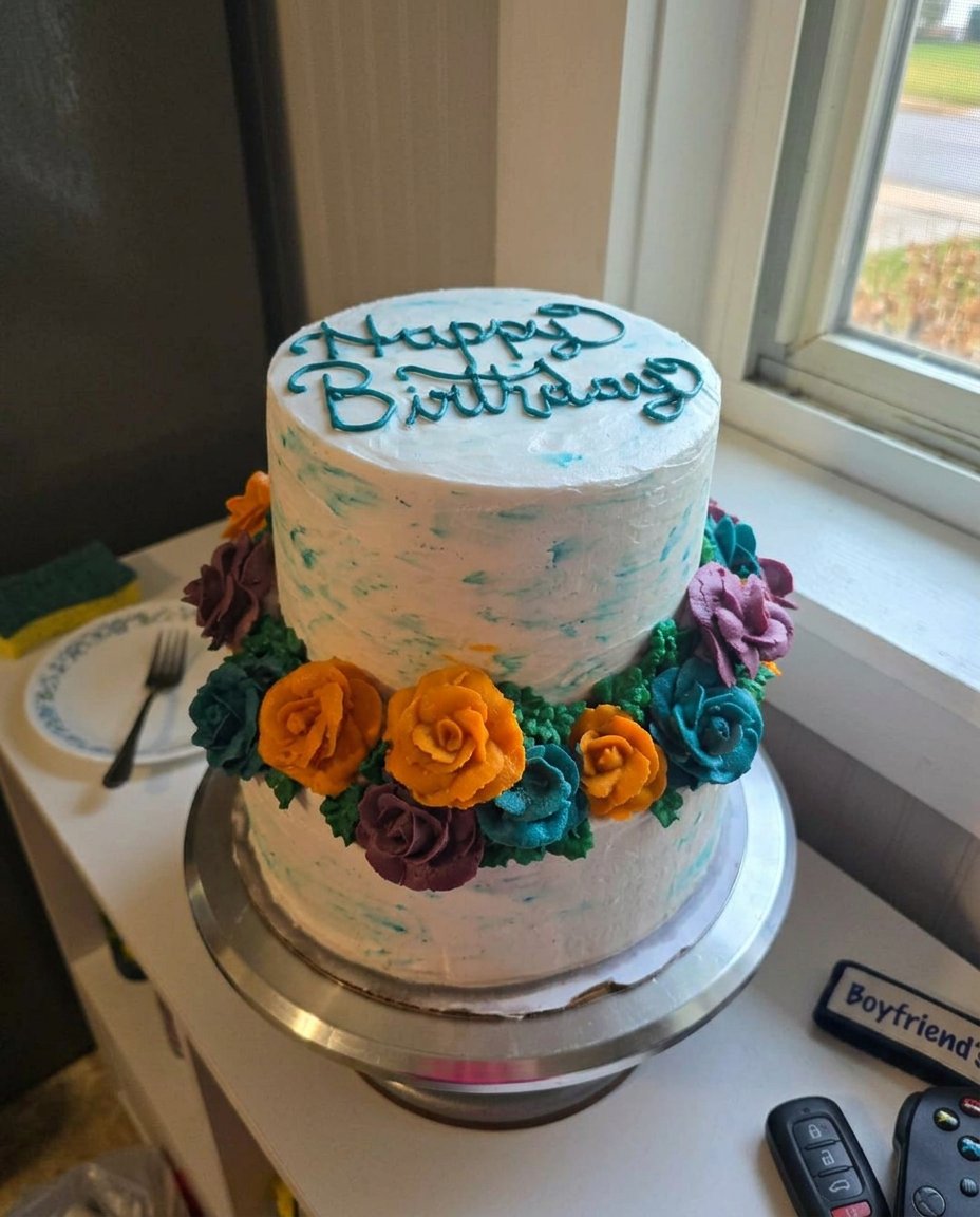A wooden spoon handle poking holes into a warm chocolate cake