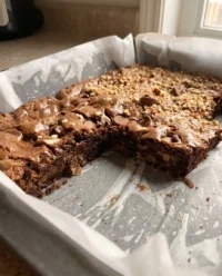 A close up of a rich brownie cake with melted chocolate chips on top