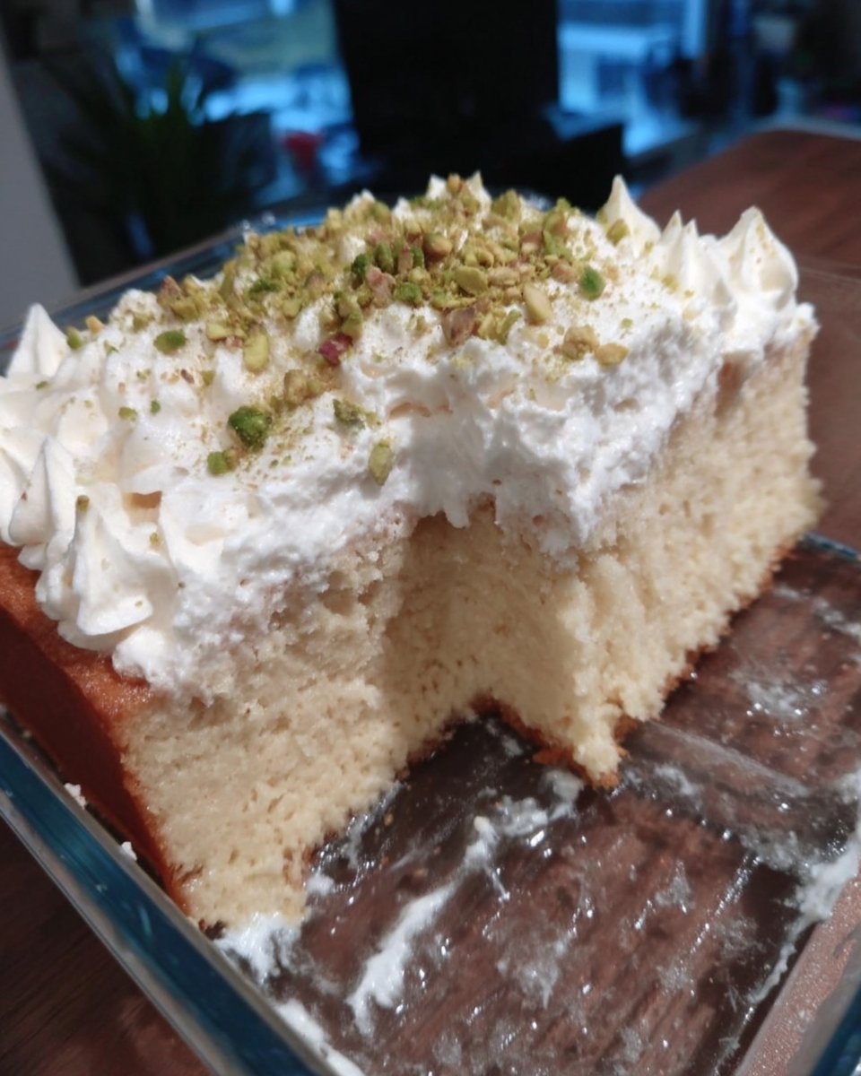 Tres Leches Cake 14 A single slice of tres leches cake on a small white plate with a fork.