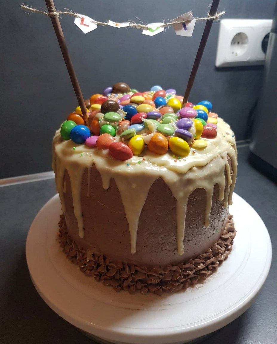 A slice of candy cake on a plate with candy spilling out from the side