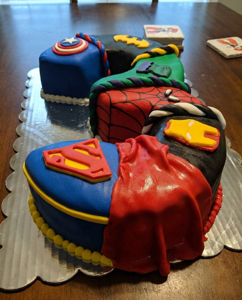 A two layer chocolate cake covered in ganache and assorted candies