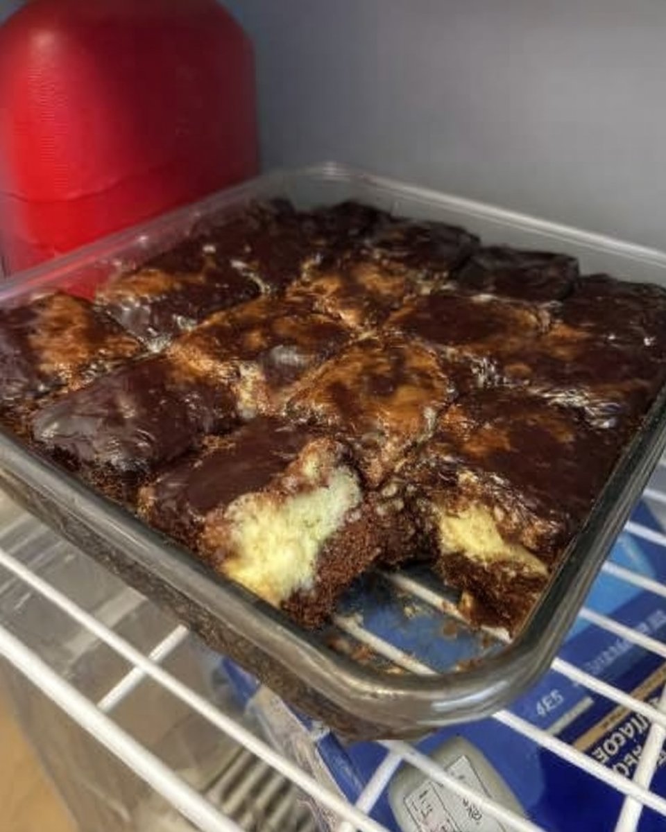 A 9x13 pan of chocolate eclair cake with a smooth chocolate frosting top