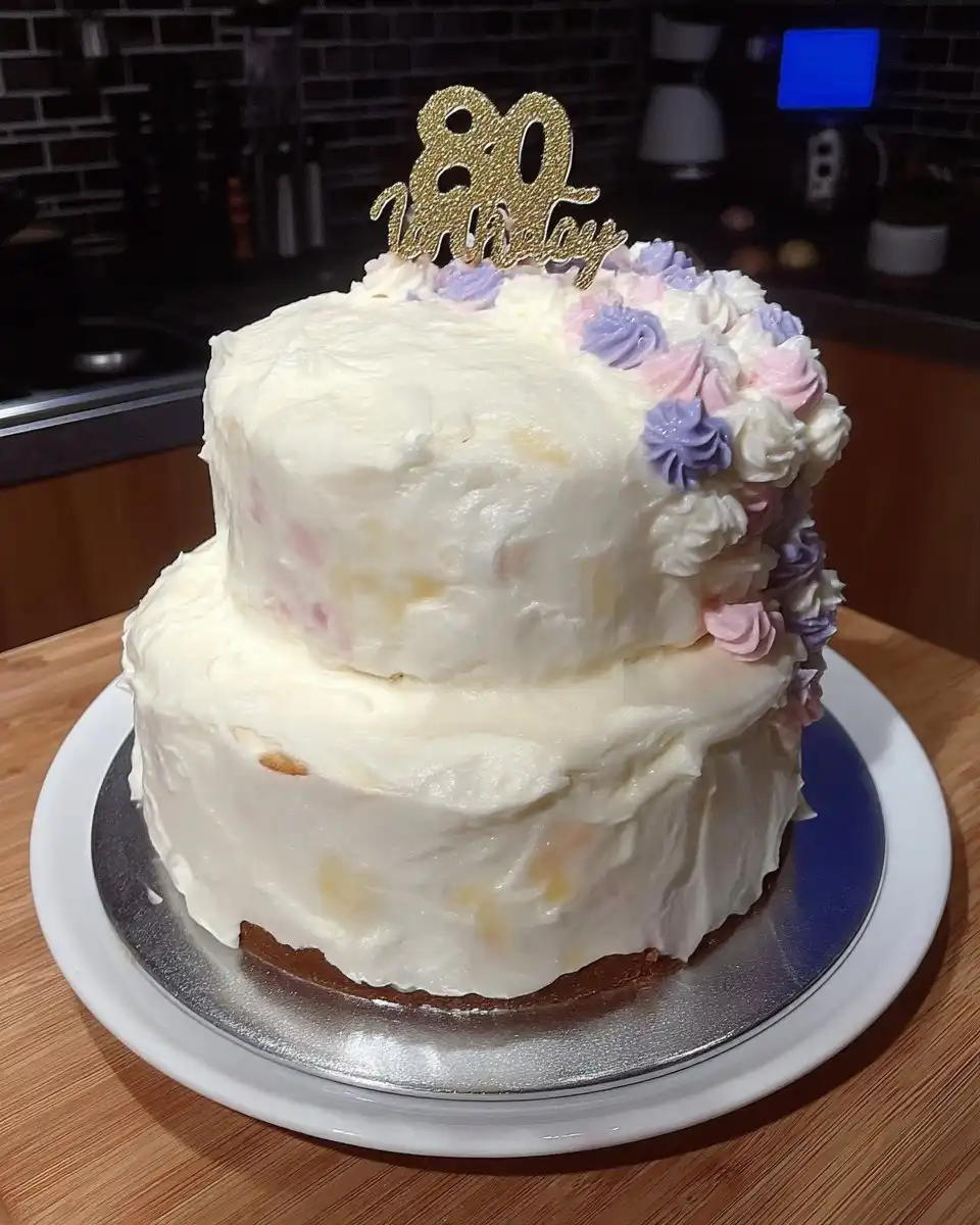 A single slice of pink floral cake on a vintage plate with a fork.