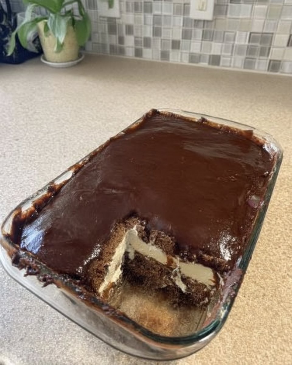 Spreading melted chocolate frosting over a layer of graham crackers