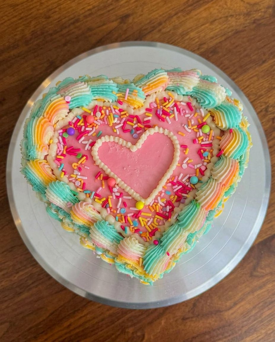 A close up of the cake layers being trimmed into a heart shape.