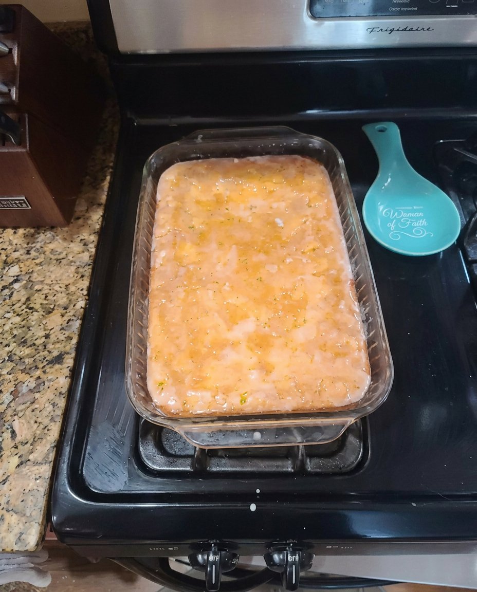 Ingredients for lemon poke cake including yellow box mix, fresh lemons, and gelatin