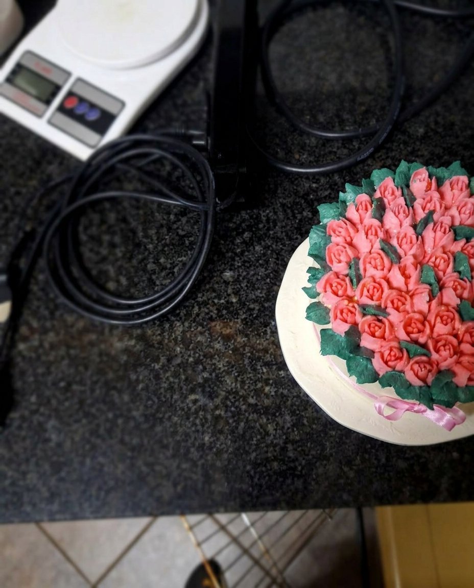 Bowls of tinted icing in burgundy green and ivory next to decorating tips