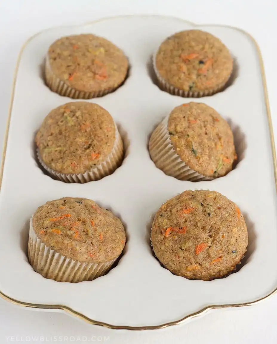 Scooping Zucchini Carrot Oatmeal Muffins batter into a muffin tin