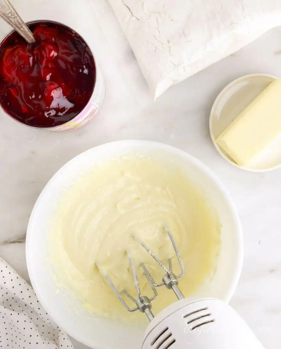 Pouring melted butter over yellow cake mix in a baking dish