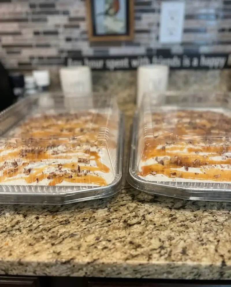 A close up slice of chocolate caramel toffee crunch cake with whipped topping
