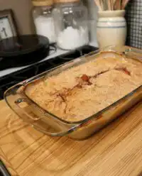 A golden brown super easy peach cobbler in a glass baking dish