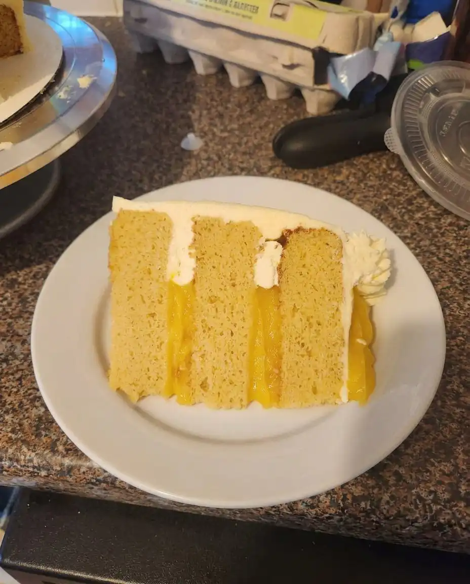 Spreading smooth vanilla frosting over a golden Orange Creamsicle Cake.