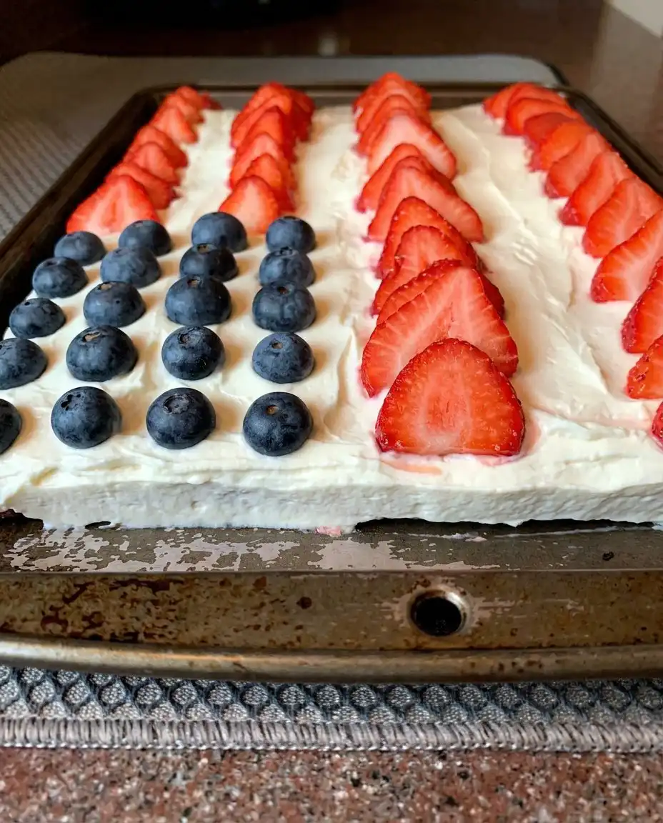 A generous slice of gluten-free American flag cake served with a scoop of vanilla ice cream